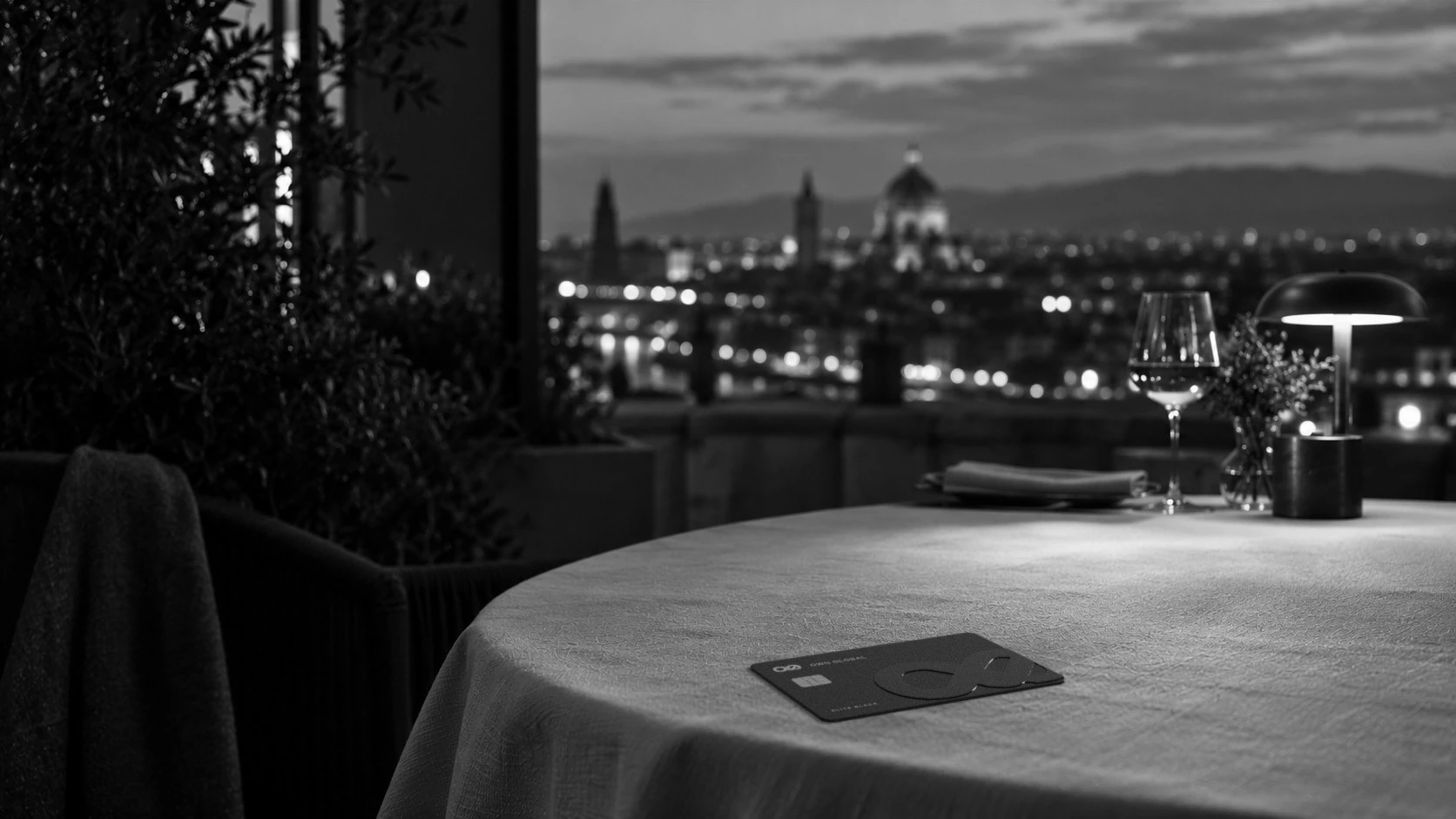 An Elite Black card on a restaurant table at dusk